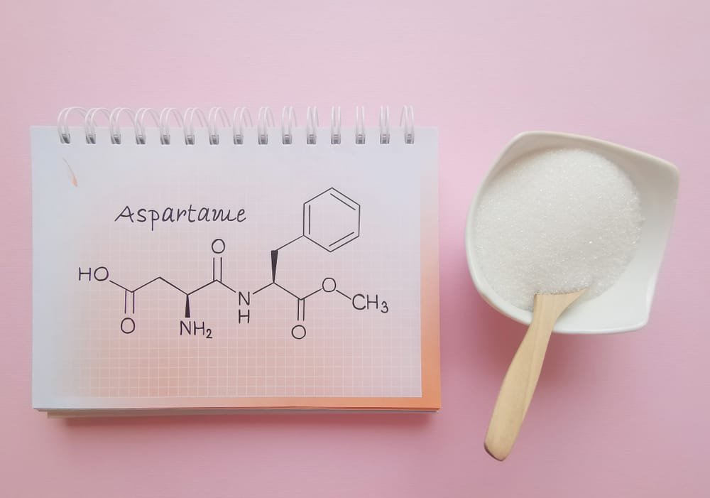 fórmula aspartame mais um recipiente com açúcar