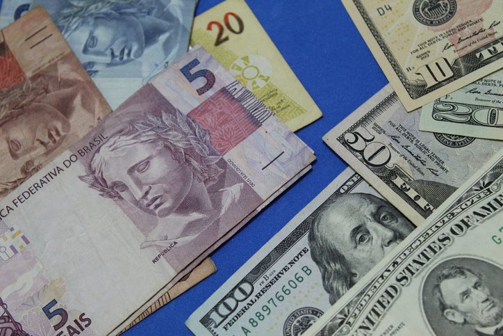 Dólar reverte perdas e opera acima de R$ 5 antes de decisões de BCs